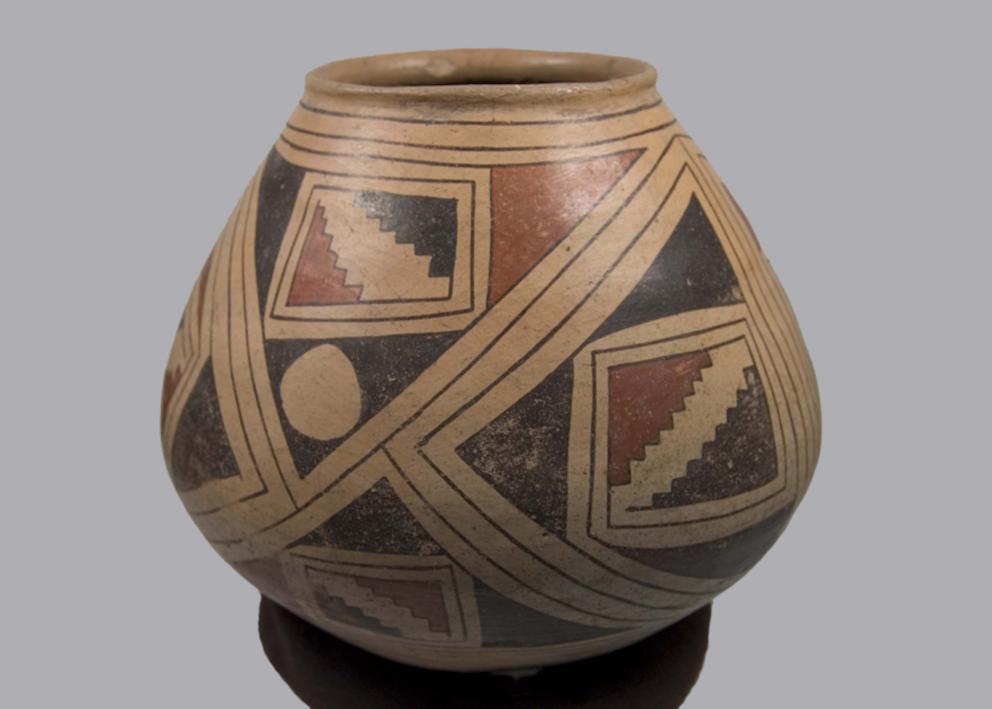 Wide bottomed clay vessel with a small opening, light brown with a two color geometric design