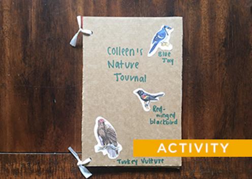 A simple nature journal made from cardboard, tied in two placed on the left with twist ties, with handwriting and stickers of birds on it